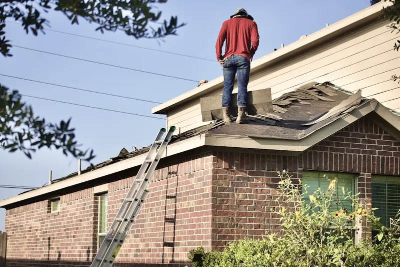 Professional roofer working on a residential roof in Spring Fields